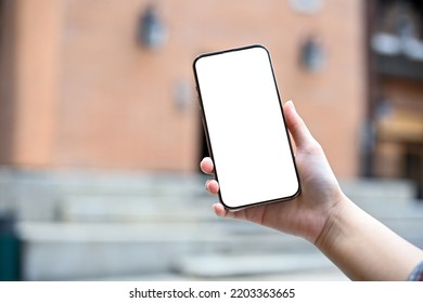 A Female Holding A Mobile Phone Over Blurred Outside Of The Community Mall In The Background. Phone White Screen Mockup