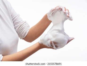 Female Holding Soap Bubbles On White Background. Hands With White Bubbles. Texture Of White Soap Foam On Female Hand.