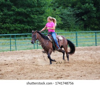 A Female Horse Trainer Riding In An Outdoor Arena