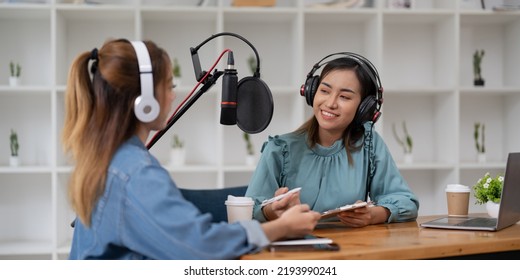 Female Host Recording Radio Podcast Interview With Guest At Home Office