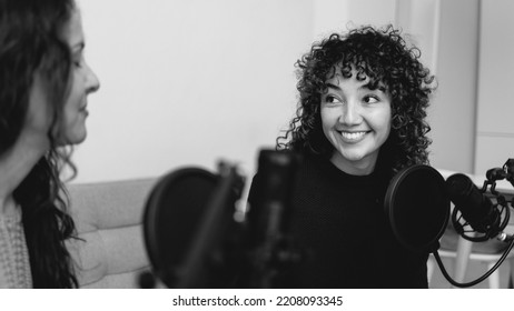 Female Host Recording Radio Podcast Interview With Guest At Home Office - Focus On Latin Girl Face - Black And White Editing