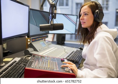 Female Host Using Control Panel At Radio Station