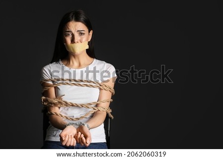 Female hostage on dark background