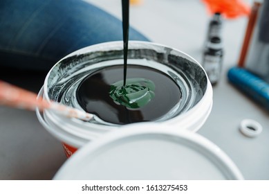 Female House Painter Mixes Black And Green Paints