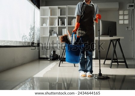 Female housekeeper smile and wearing glove, preparing to clean office