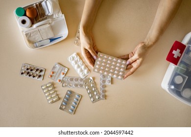 Female housewife checking medicines at domestic first aid kit neatly placing storage organization. Woman keeping vitamin, painkiller, bandage, antibiotics, blister. Container with pharmacy cure - Shutterstock ID 2044597442
