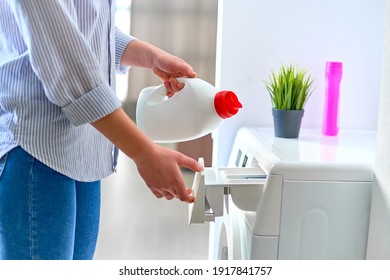 Female housewife pouring fabric softener gel into a modern washing laundry machine  - Shutterstock ID 1917841757