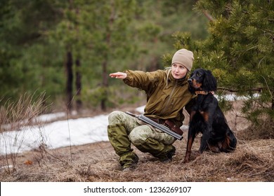 Female hunter in camouflage clothes ready to hunt, holding gun and walking in forest. hunting and people concept