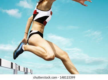 Female hurdle runner leaping over the hurdle - Powered by Shutterstock