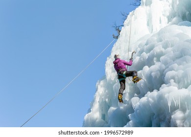 Female Ice Climber Silhouette Swinging Axes Into The Ice With Force, The Shattered Ice Falling