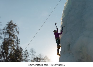 Female Ice Climber Silhouette Swinging Axes Into The Ice With Force, The Shattered Ice Falling