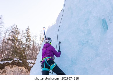 Female Ice Climber Silhouette Swinging Axes Into The Ice With Force, The Shattered Ice Falling