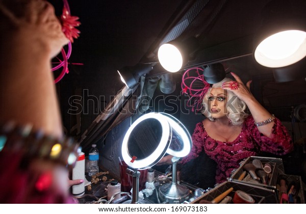 Female
impersonator adjusting hair in dressing
room