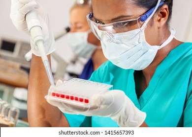 Female Indian Asian Woman Scientist Or Doctor Using A Pipette And Sample Tray For Blood Test In A Medical Research Lab Or Laboratory