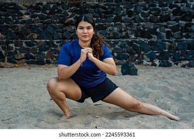A female Indian athlete stretches outdoors.