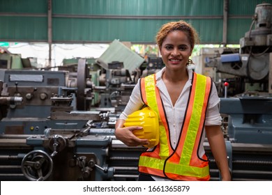Female Industrial Engineer Holding Hard Hat While Standing In The Heavy Industry Manufacturing Factory