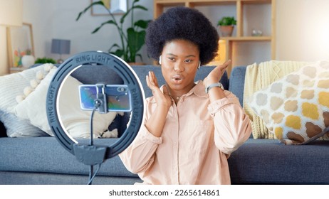 Female influencer and vlogger recording content on a phone at home. Young creator live streaming online for a vlog channel. Filming a podcast while speaking to followers and viewers on social media - Powered by Shutterstock