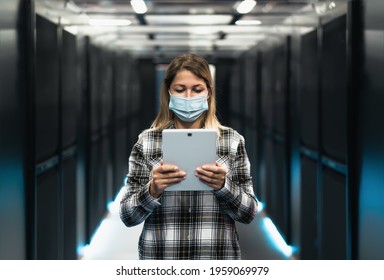 Female Informatic Engineer Working Inside Server Room Database While Wearing Face Mask During Corona Virus Outbreak