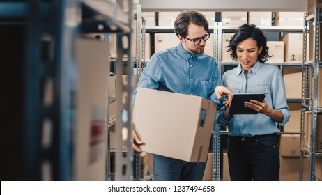 Female Inventory Manager Shows Digital Tablet Information to a Worker Holding Cardboard Box, They Talk and Do Work. In the Background Stock of Parcels with Products Ready for Shipment. - Shutterstock ID 1237494658