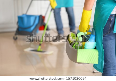 Female janitor with cleaning supplies in kitchen Foto d'archivio © 