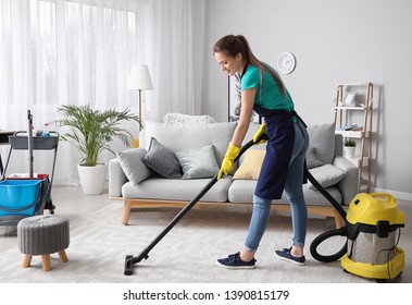 Female Janitor With Vacuum Cleaner In Room