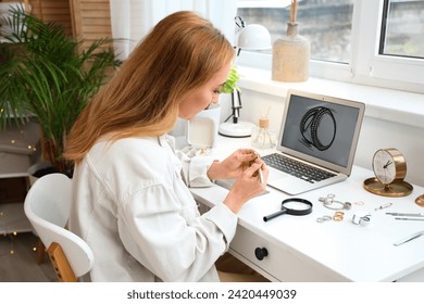 Female jeweler examining ring at table in workshop - Powered by Shutterstock