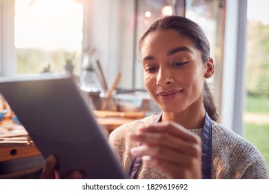 Female Jeweller Comparing Ring With Drawn Design On Digital Tablet In Studio - Powered by Shutterstock