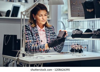 Female Jewelry Worker Showing A Black Box With For Precious Earrings In A Luxury Jewelry Store.