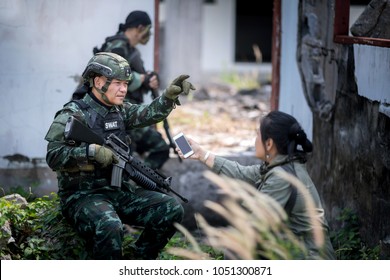 Female Journalist Interview Soldier During War Conflict. Photojournalist  Work On Grass Field Concept.