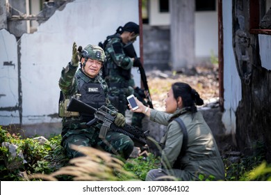 Female Journalist Interview Soldier During War Conflict. Photojournalist  Work On Gress Field Concept.