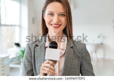 Female journalist with microphone in office