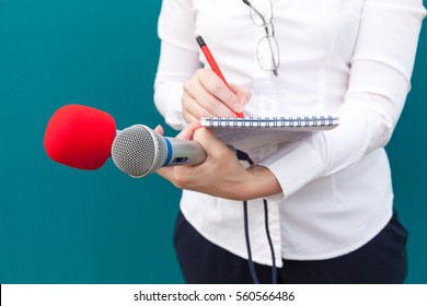 Female Journalist At News Conference, Writing Notes, Holding Microphones