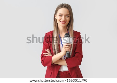 Female journalist on light background