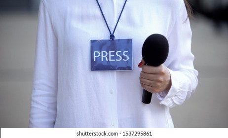 Female Journalist With Press Id Holding Microphone, Preparing For Interview