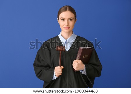 Female judge with book on color background