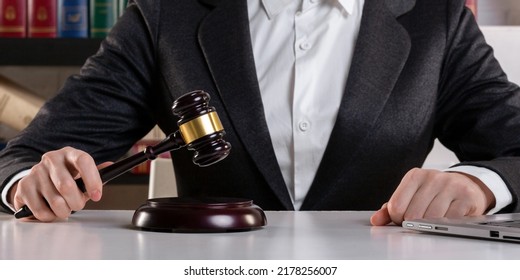 Female Judge Hands In Formal Wear With Maroon Auction Gavel And Open Laptop On A Desk Surface In An Office, Front View, Selected Focus. On-line Tender, Remote Judicial Process, Electronic Trading