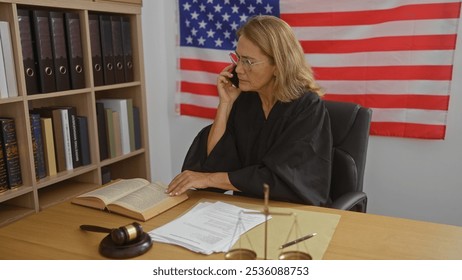 Female judge reading a book while on the phone in an american office with a balance scale, papers, gavel, and flag in the background - Powered by Shutterstock