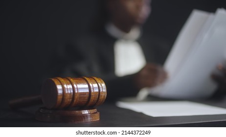 Female Judge Working With Papers In Court Room, Gavel On Table, Justice Symbol