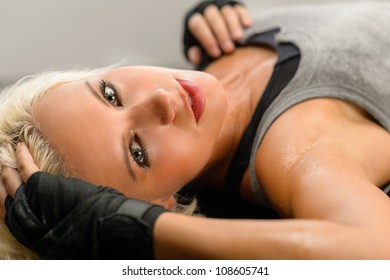 Female kick-boxer laying down on black plexiglass fitness studio - Powered by Shutterstock