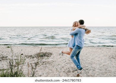 Female kisses male on beach ocean and enjoys sunny summer day. Man embraces woman stands on sand sea. Couple in love hugging and kissing each other on seashore. Spending time together. - Powered by Shutterstock