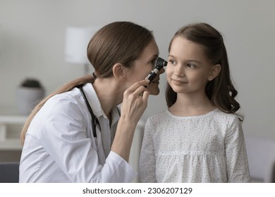 Female laryngologist in white coat using professional otoscope instrument examining little girl ear during her visit in clinic. Otolaryngology, children healthcare, inflammation infection prevention - Powered by Shutterstock