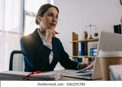 Female Lawyer In Eyeglasses At Workplace With Documents And Laptop In Office