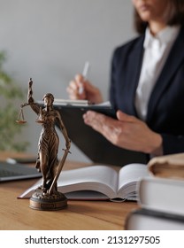 female lawyer or judge checks documents or a contract and makes notes in a notebook and phone, is engaged in the registration of divorce proceedings. work in a law firm in the office. european young - Shutterstock ID 2131297505