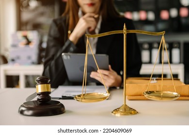 Female lawyer in the office with brass scale on wooden table. justice and law concept in morning light