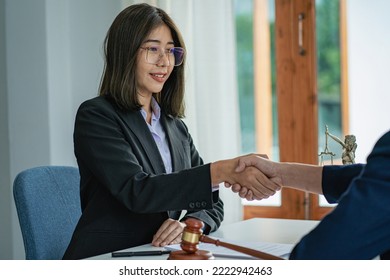 A female lawyer shakes hands between lawyer and client after agreeing a contract in a court case. To hope for victory over legitimate fighters, consulting ideas. - Shutterstock ID 2222942463