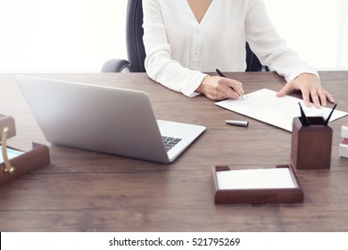 Female lawyer signing documents in office