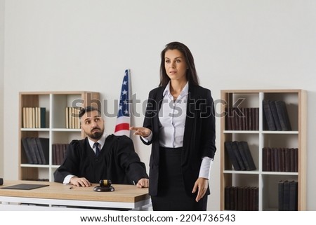 Female lawyer speak to audience during court trial in United States. Woman attorney or juror make speech defend client in lawsuit or criminal prosecution. Law and order. Legislation concept.