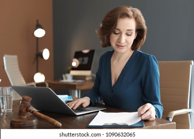 Female Lawyer Working With Laptop At Table In Office