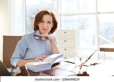 Female lawyer working at table in office - Shutterstock ID 1084698029