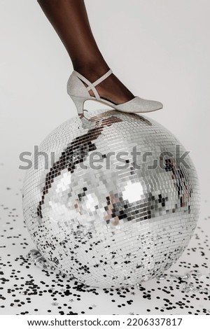 Female leg on disco ball.